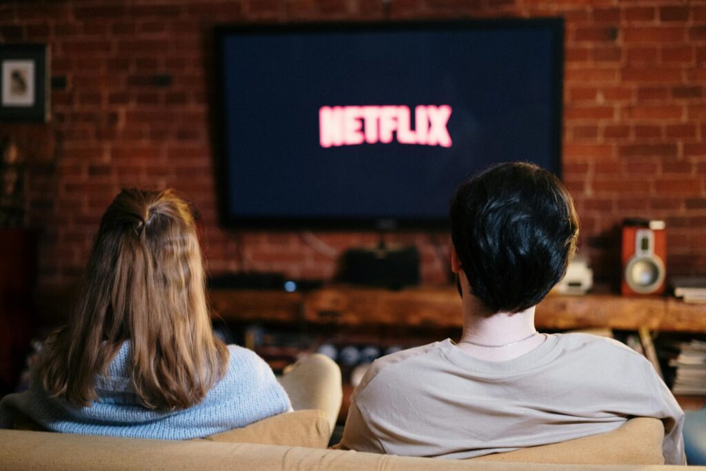 Beitragsfoto Netflix zwei Personen schauen auf den Fernseher und sehen das Netflix Logo